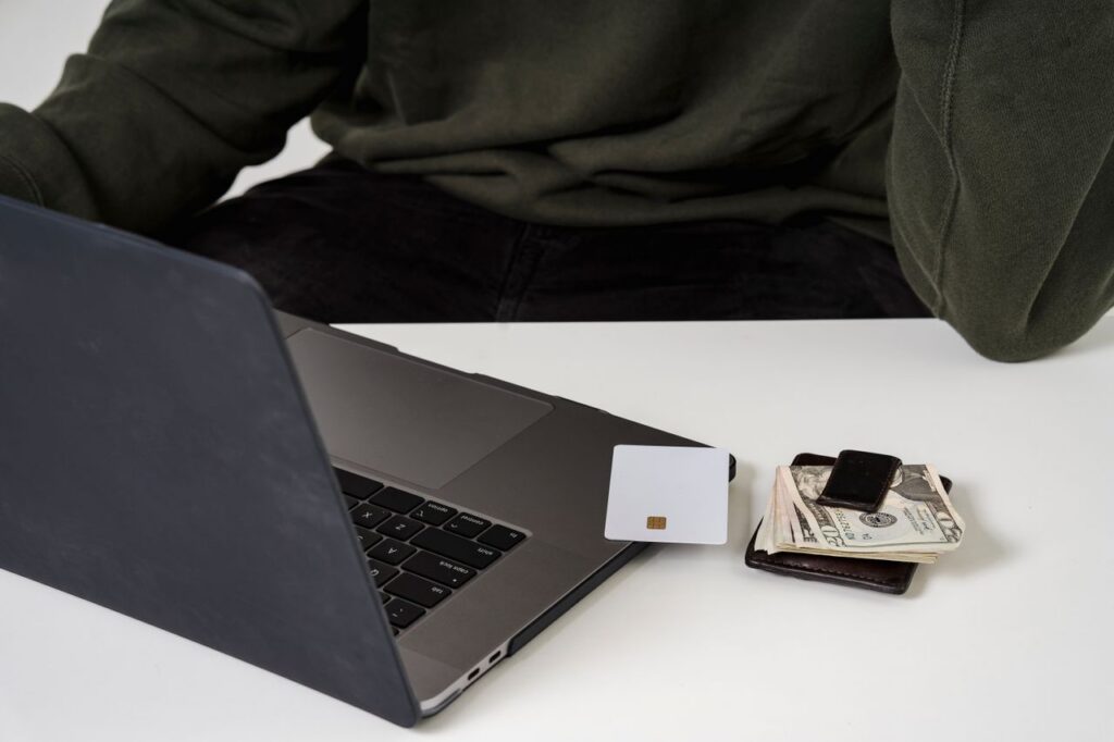 A man using a laptop and credit card for online shopping, highlighting e-commerce convenience.